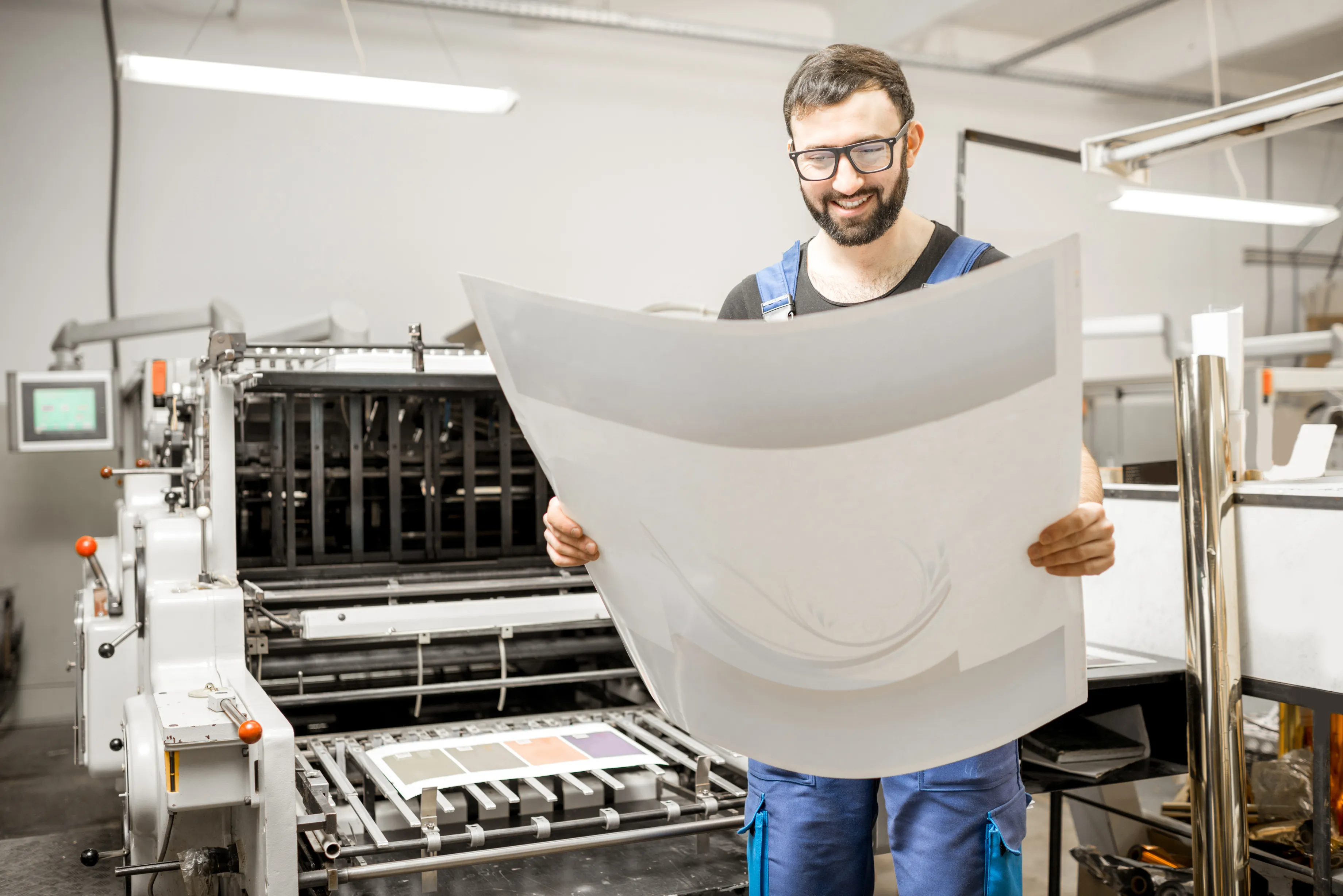 Fotografía de un Trabajador que sabe qué es una imprenta feliz por el resultado de sus impresiones